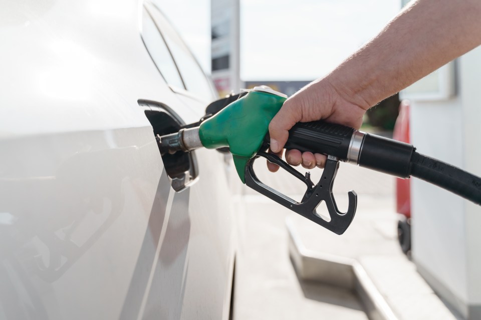 a person is pumping gas into a car at a gas station