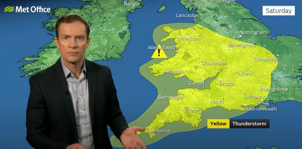 a man stands in front of a met office map