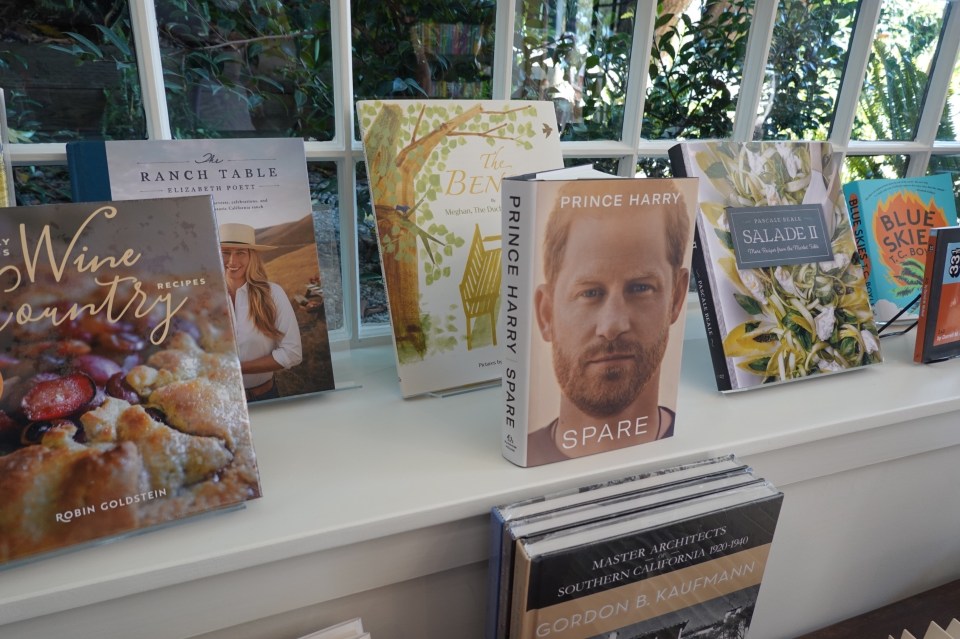 several books on a shelf including prince harry 's spare