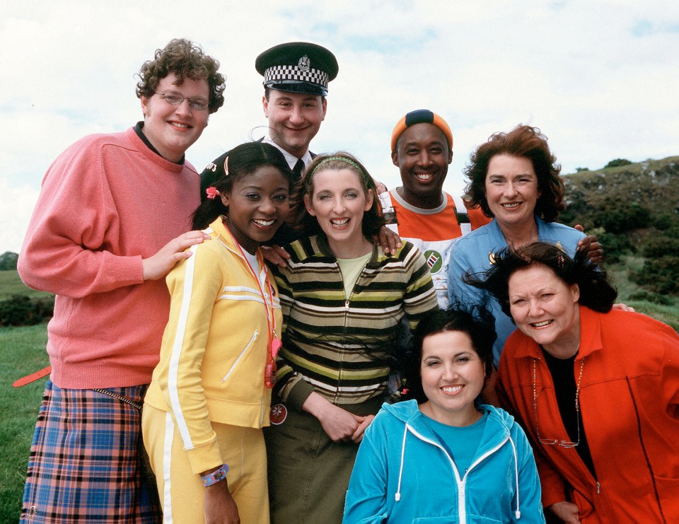 a group of people posing for a picture including a man in a police hat