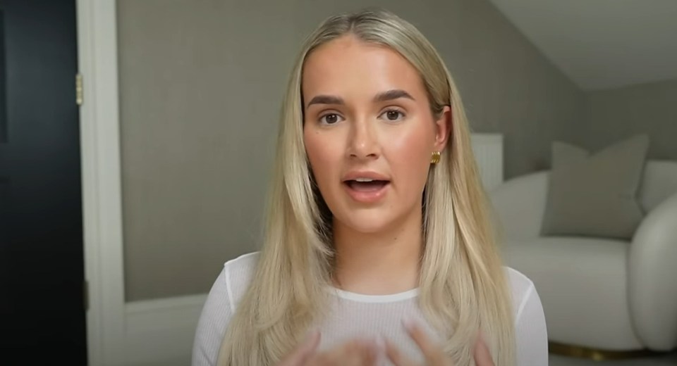 a woman with blonde hair is wearing earrings and a white shirt
