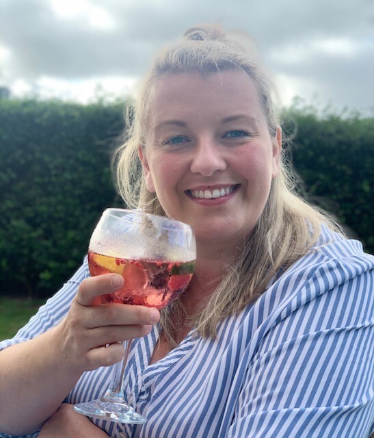 a woman in a striped shirt is holding a glass of wine