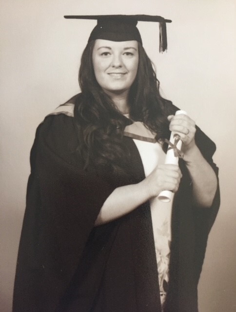 a woman in a graduation cap and gown is holding a diploma