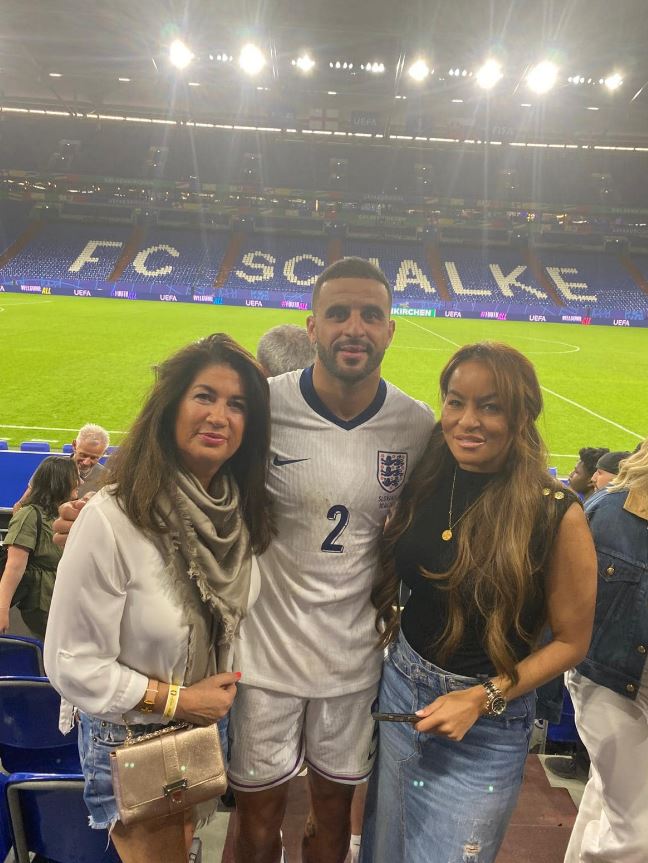 a man with the number 2 on his jersey poses with two women