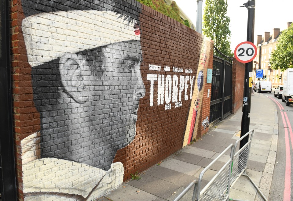 a brick wall with a painting of a man named thorpey