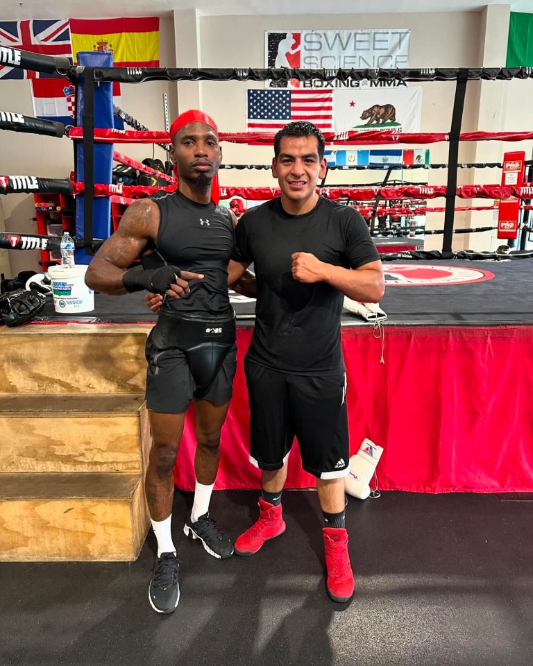 two boxers pose in front of a sweet science boxing ring