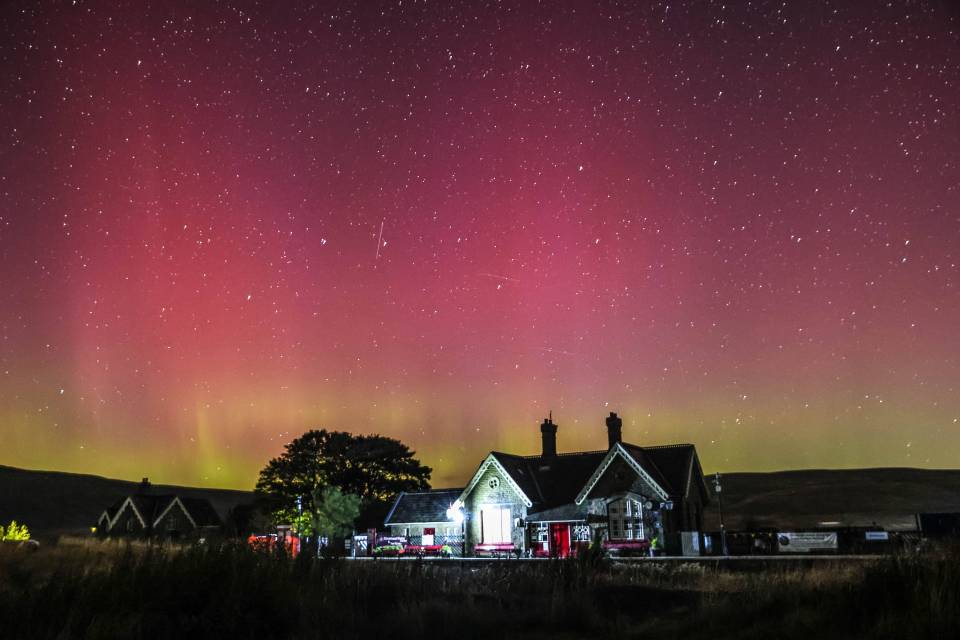 a house is lit up under a starry sky