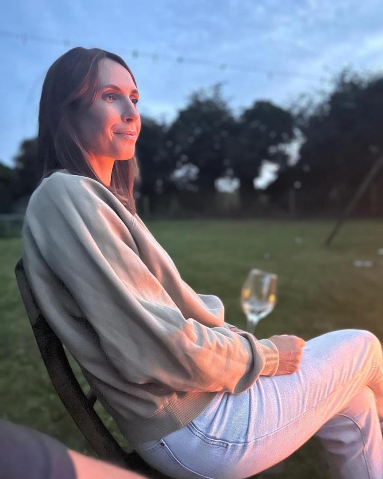 a woman sits in a chair with a glass of wine