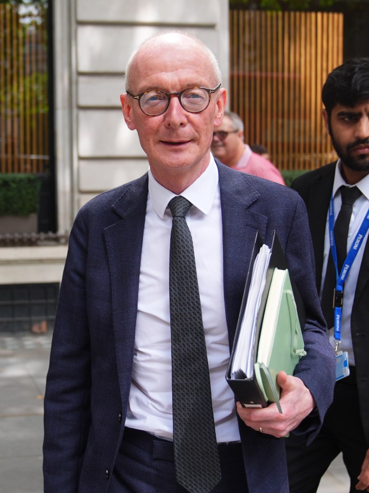 a man in a suit and tie has a lanyard around his neck that says ' bbc ' on it