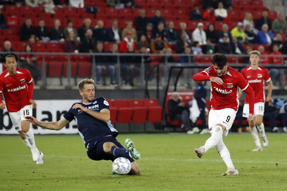 a soccer player wearing a kansino jersey kicks the ball