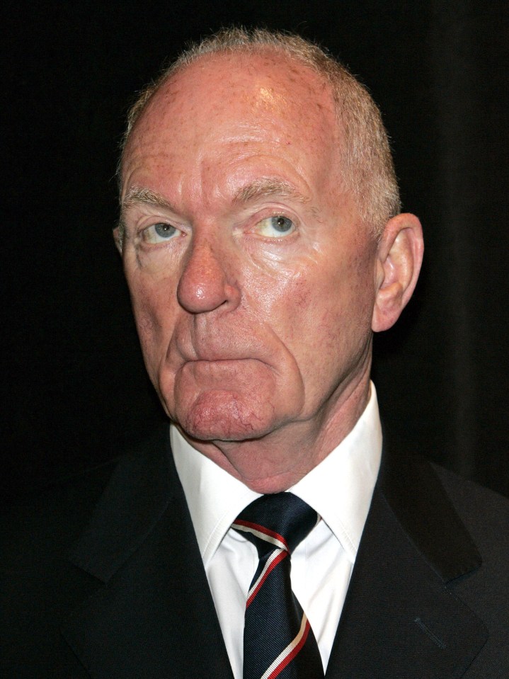 a man in a suit and tie looks at the camera