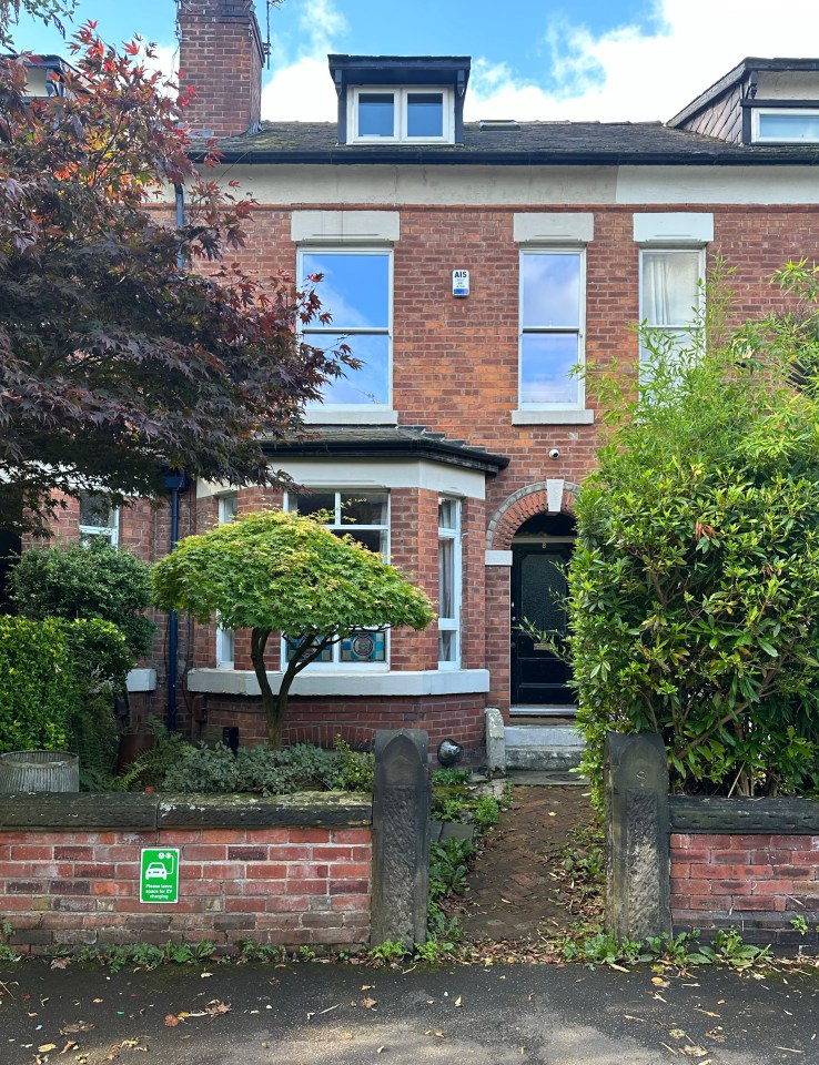 the front of a brick house with a green sign that says ' no parking '