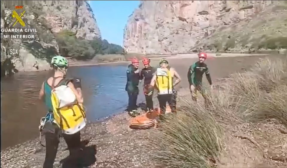 a group of people standing next to a river with a sign that says guardia civil