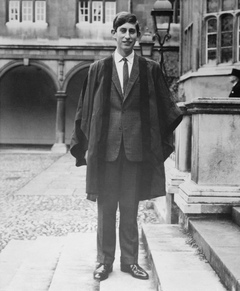 a black and white photo of a young man in a suit and cape