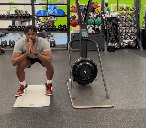 a man squatting in front of a machine that has the number 55 on it