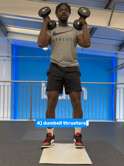 a man in a nike shirt is lifting dumbbells in a gym