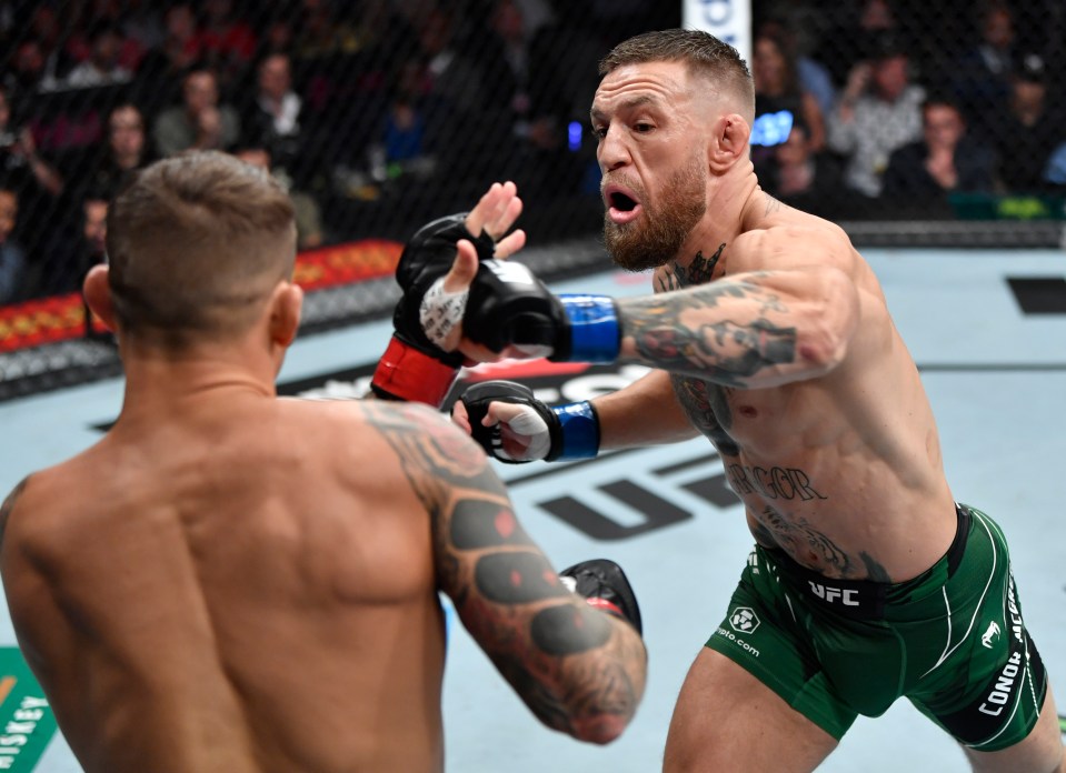 two men in a boxing match with one wearing green shorts that say ufc