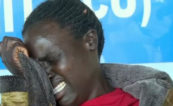 a woman is crying and covering her face with her hand .