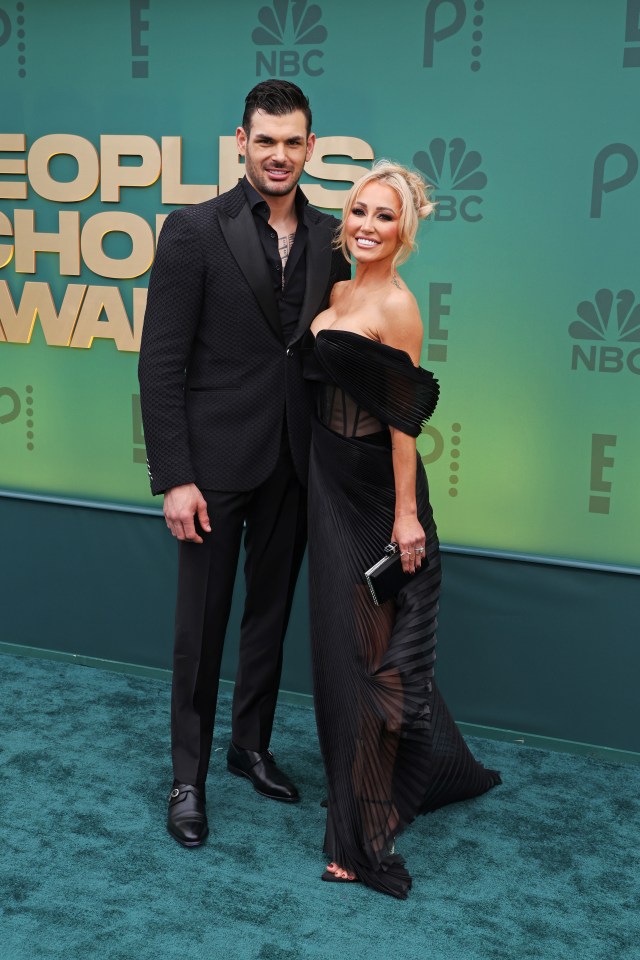 a man and a woman are posing for a picture on a green carpet that says people 's choice awards