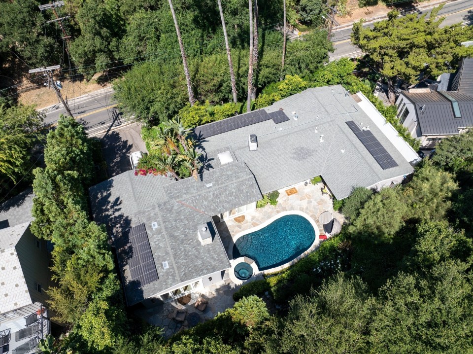 an aerial view of a house with a pool and solar panels on the roof