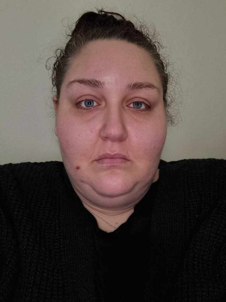a woman with blue eyes and a black sweater looks at the camera
