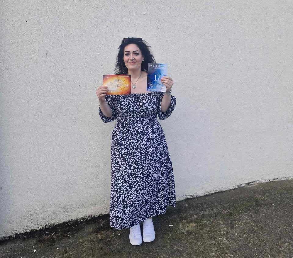 a woman in a black and white dress is holding two books