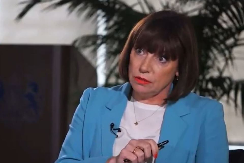 a woman in a blue jacket is holding a pen in her hand .