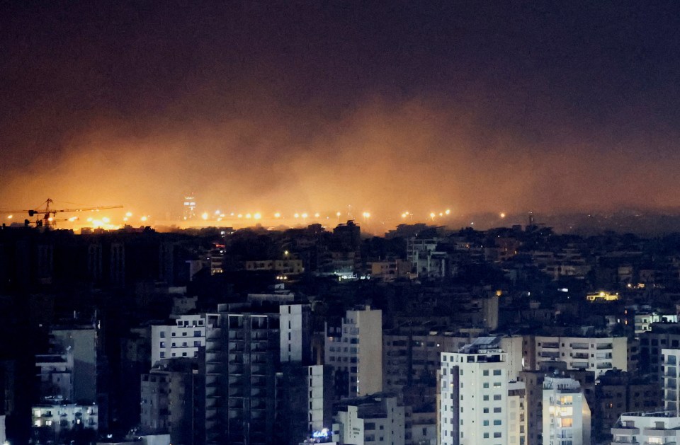 a city at night with a fire in the distance