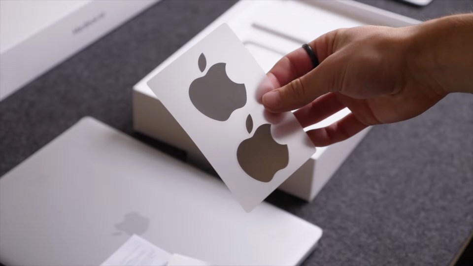 a person is holding a card with the apple logo on it