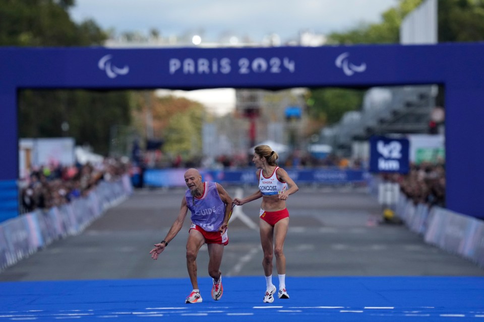 a man and a woman are running in front of a sign that says paris 2024