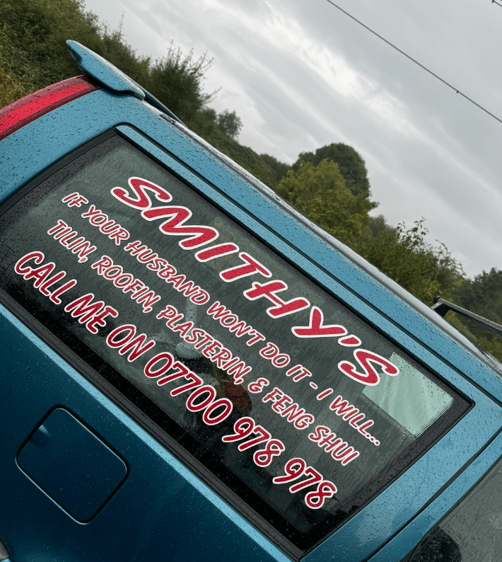 a blue car with a smithy 's sign on the back window
