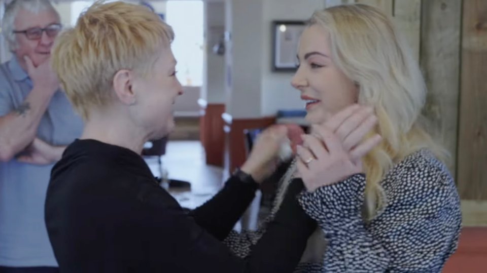 a woman with a ring on her finger looks at another woman