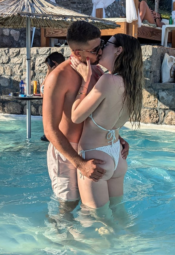 a man and a woman kissing in a swimming pool