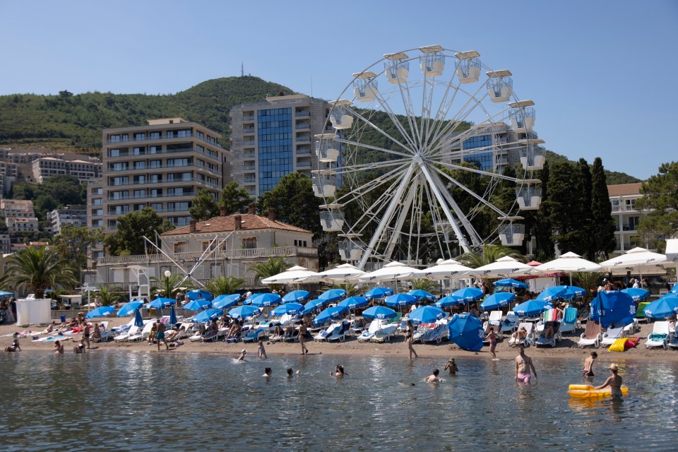 a large ferris wheel is in the middle of a beach