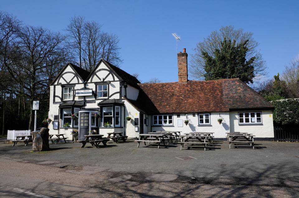 a small white building with a sign that says ' the brook inn ' on it
