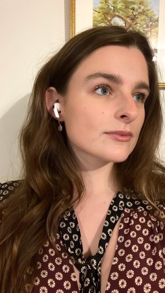 Woman wearing an earring and an earbud.