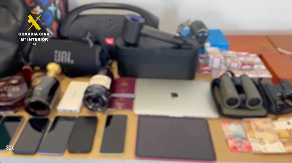 a table with a bunch of money and binoculars with a guardia civil logo in the background