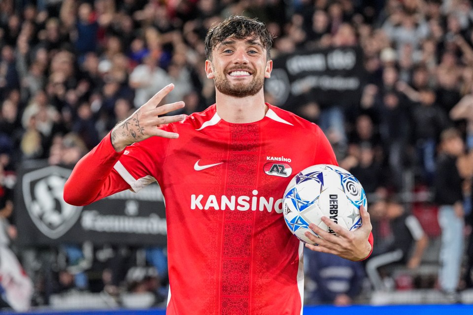 a man in a red kansino jersey holds a soccer ball