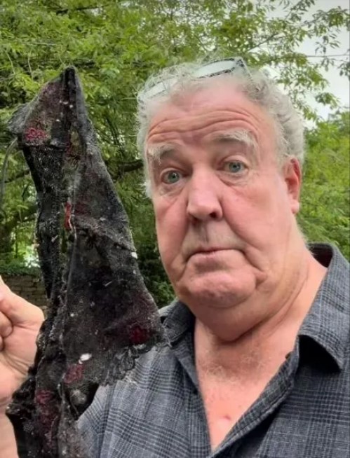 a man is holding a piece of black lace and making a funny face .