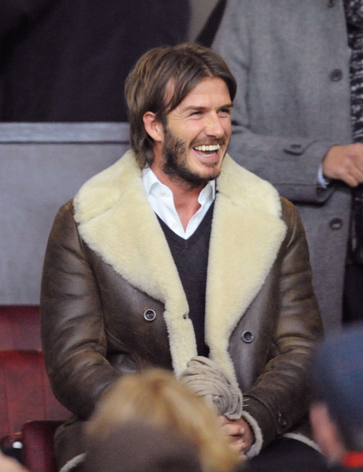 a man wearing a fur coat is smiling in a crowd