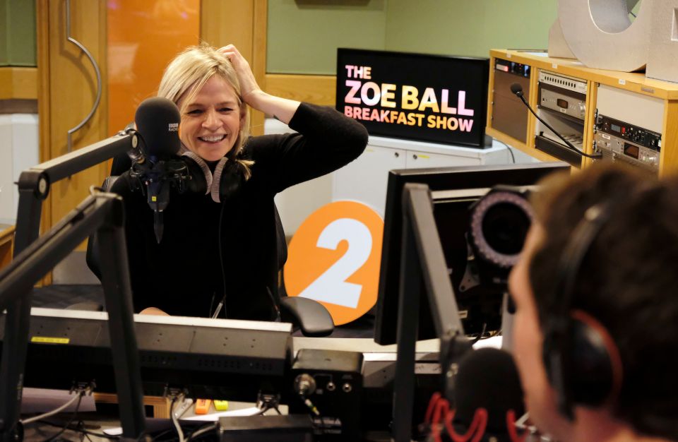 a woman in front of a sign that says the zoe ball breakfast show