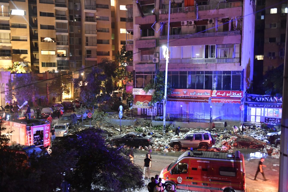 a red ambulance is parked in front of a building that says adnan