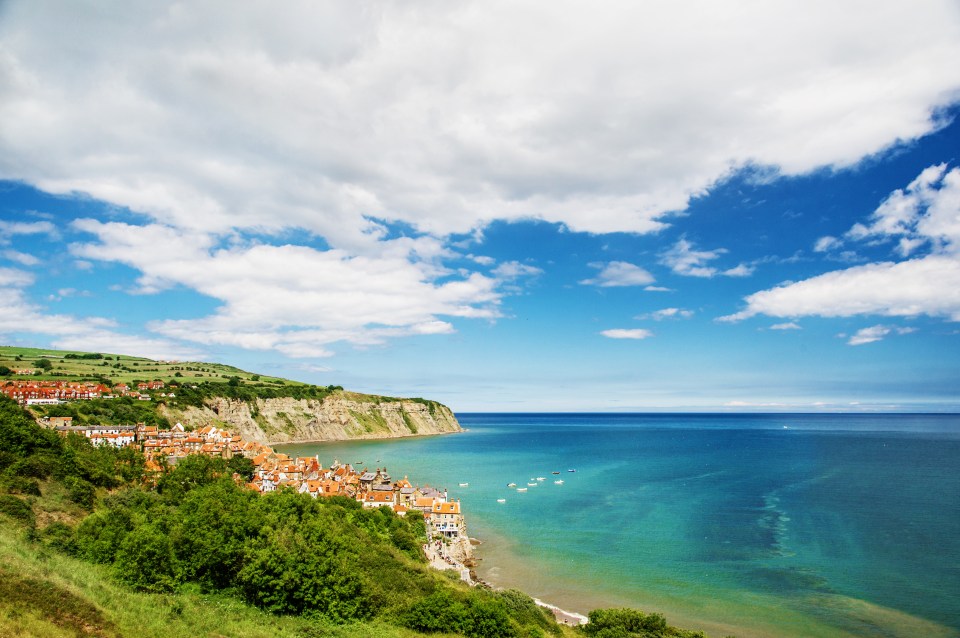 a small town sits on a cliff overlooking the ocean