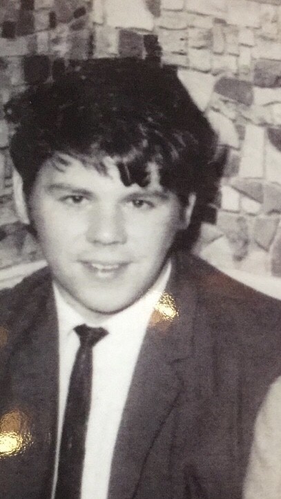 a black and white photo of a young man in a suit and tie