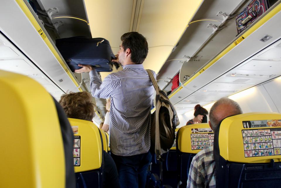 a man carrying a suitcase on top of an airplane
