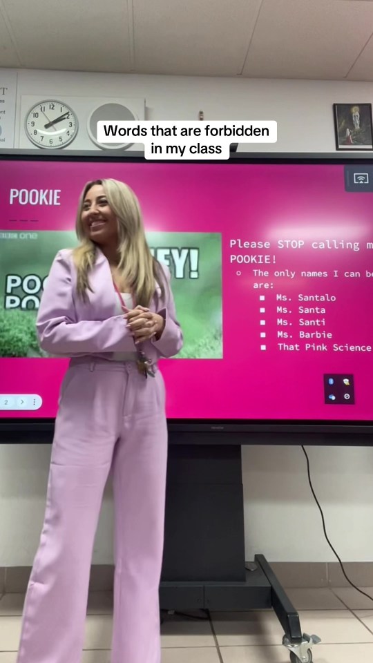 a woman stands in front of a screen that says pookie