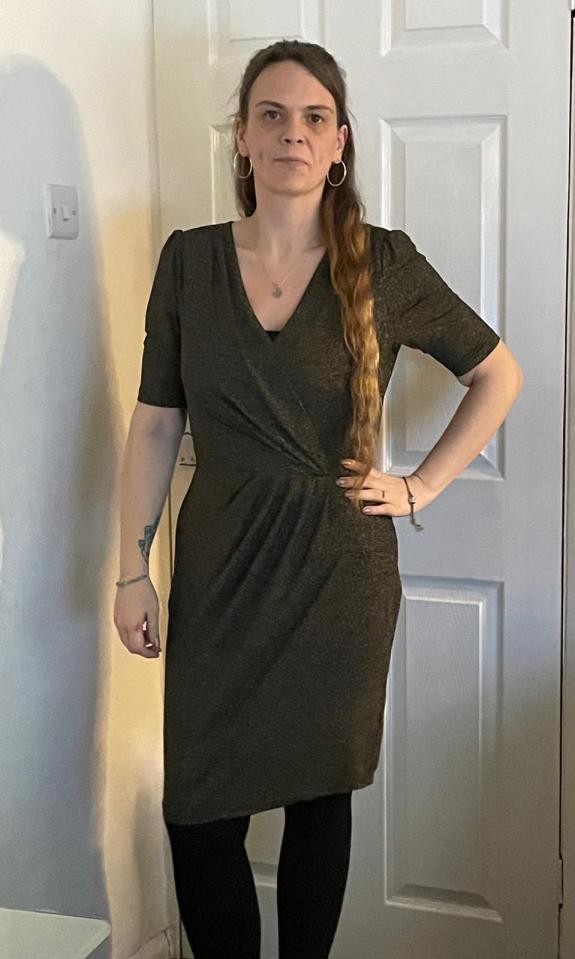 a woman in a black dress stands in front of a white door