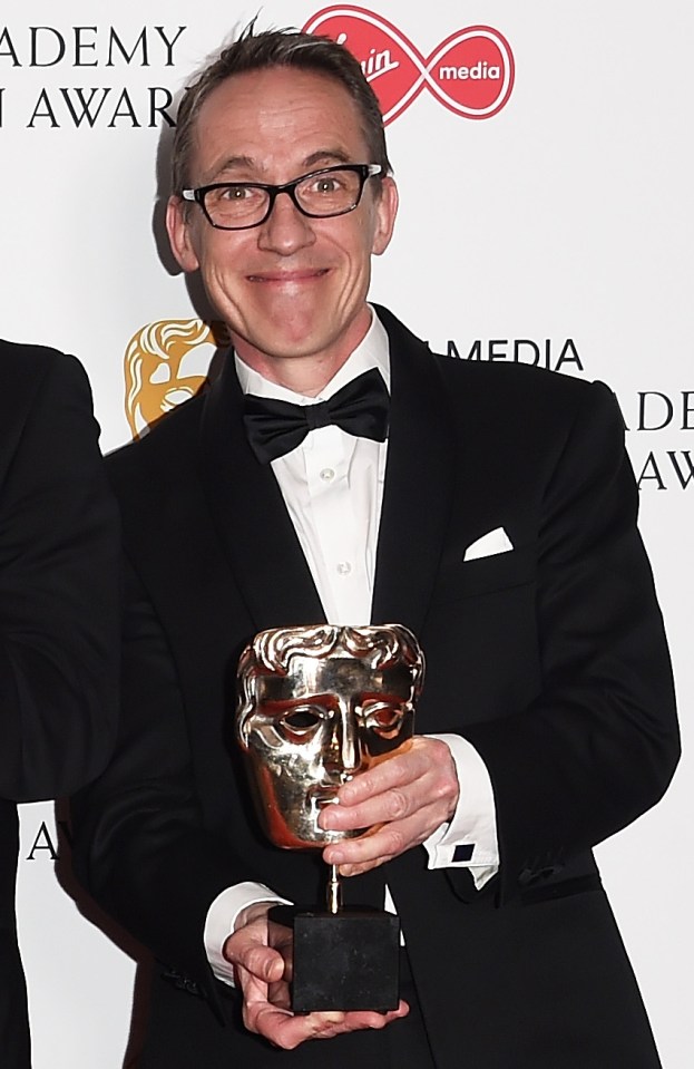 a man holding a trophy in front of a sign that says media