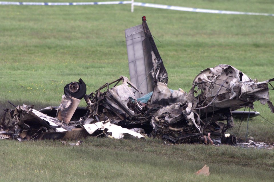a wreckage of a plane is laying in a grassy field