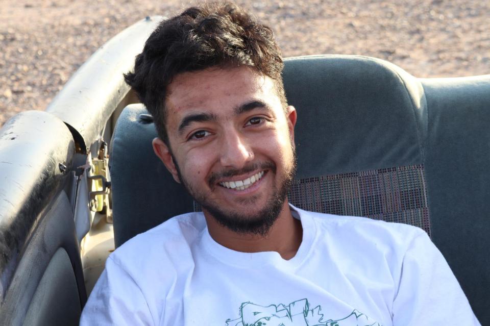 a man wearing a white shirt with the word earth on it